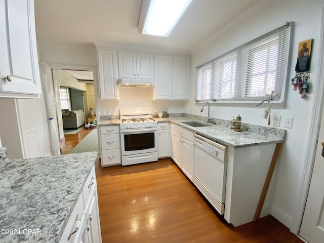 kitchen featuring light stone counters, white cabinetry, sink, light hardwood / wood-style floors, and white appliances