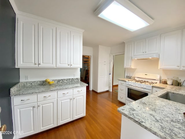 kitchen with light stone counters, white cabinets, hardwood / wood-style floors, sink, and white range with gas stovetop