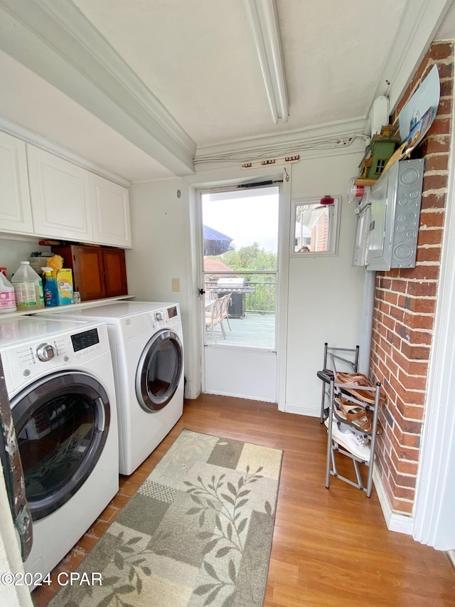 laundry area with cabinets, crown molding, light wood-type flooring, and washing machine and clothes dryer