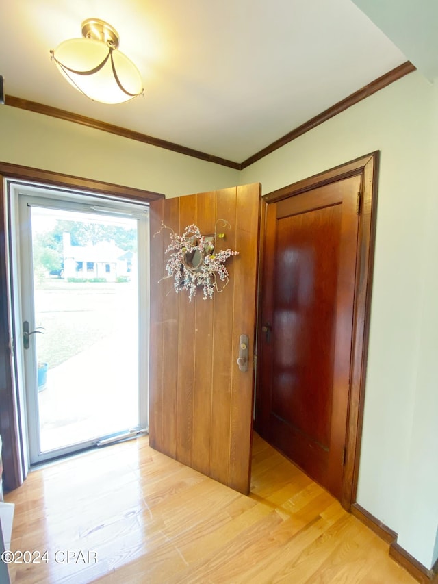 entryway featuring light hardwood / wood-style floors and crown molding