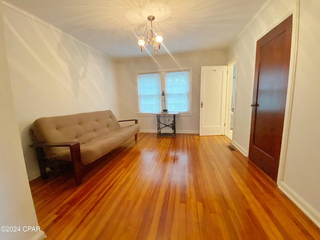 unfurnished room featuring wood-type flooring, a notable chandelier, and crown molding