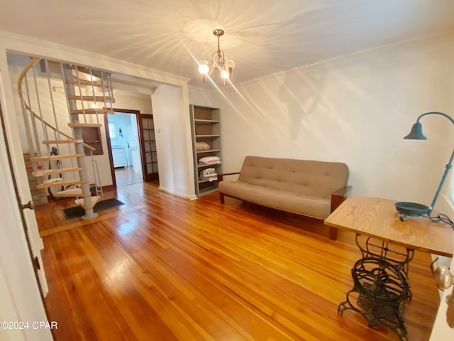 sitting room with hardwood / wood-style flooring, a chandelier, and ornamental molding