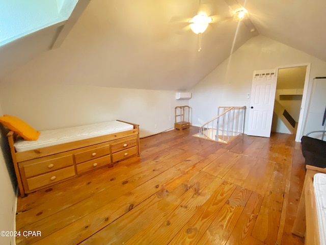 bonus room with hardwood / wood-style flooring, lofted ceiling with skylight, and ceiling fan