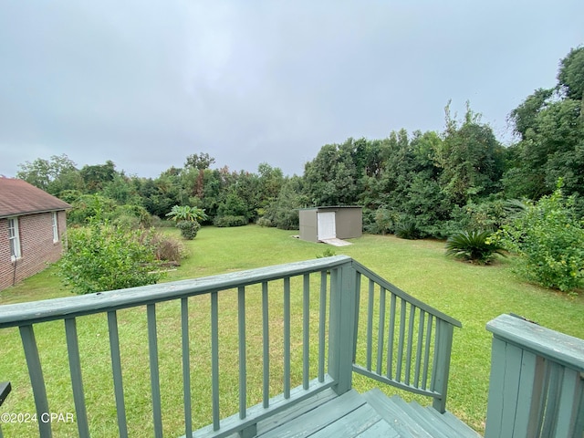 wooden terrace with a shed and a lawn