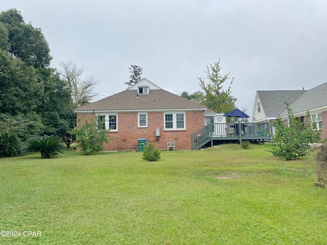 back of house featuring a wooden deck and a yard