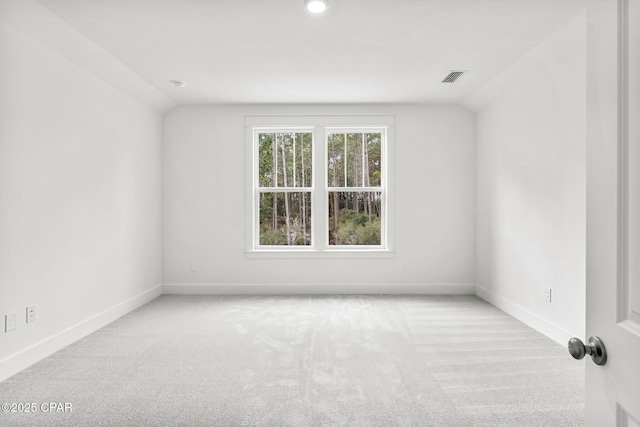 carpeted spare room with lofted ceiling