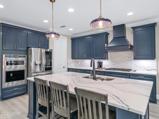 kitchen featuring custom exhaust hood, appliances with stainless steel finishes, sink, and a kitchen island with sink