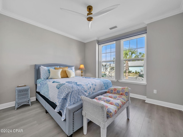 bedroom featuring light hardwood / wood-style floors, ceiling fan, and ornamental molding