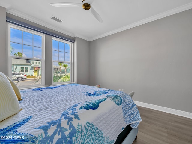 bedroom featuring ceiling fan, dark hardwood / wood-style flooring, and ornamental molding