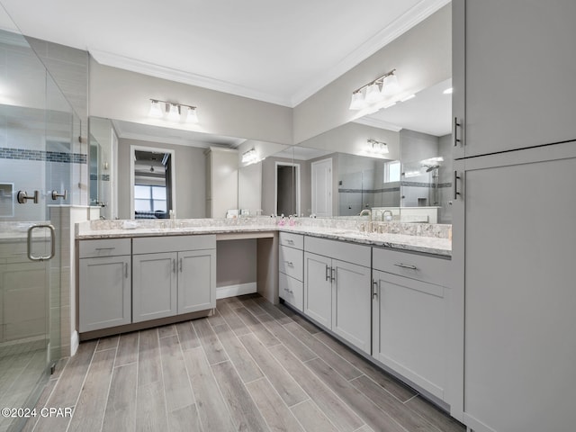 bathroom featuring hardwood / wood-style flooring, vanity, an enclosed shower, and crown molding