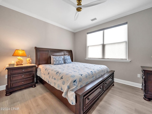 bedroom with light wood-type flooring, ceiling fan, and crown molding