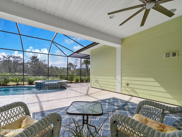 view of patio featuring ceiling fan, glass enclosure, and a swimming pool with hot tub