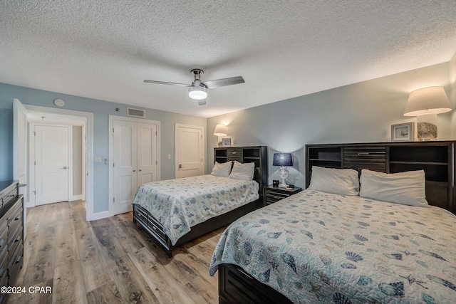 6201 Thomas Dr Unit 302, Panama City, FL 32408 - bedroom with wood finished floors, a textured ceiling, baseboards, visible vents, and ceiling fan