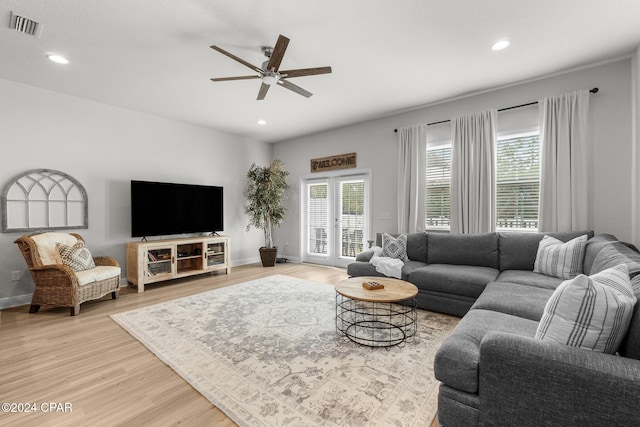 living room featuring light hardwood / wood-style floors and ceiling fan