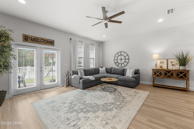 living room featuring french doors, light wood-type flooring, and ceiling fan