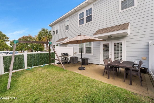 rear view of property featuring a lawn, cooling unit, and a patio area