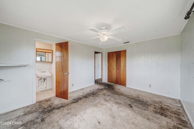 unfurnished bedroom with sink, ceiling fan, carpet flooring, connected bathroom, and a closet