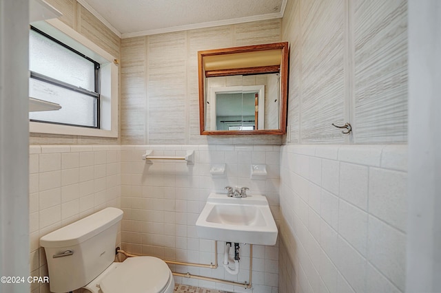 bathroom featuring toilet, tile walls, and sink