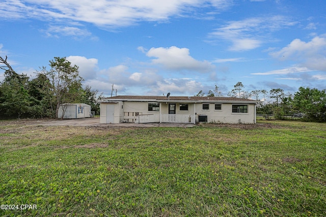 rear view of house with central AC unit, a yard, and a deck