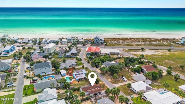 birds eye view of property with a water view and a beach view