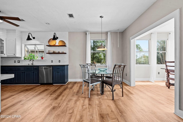 dining area with light hardwood / wood-style floors, ceiling fan, and sink