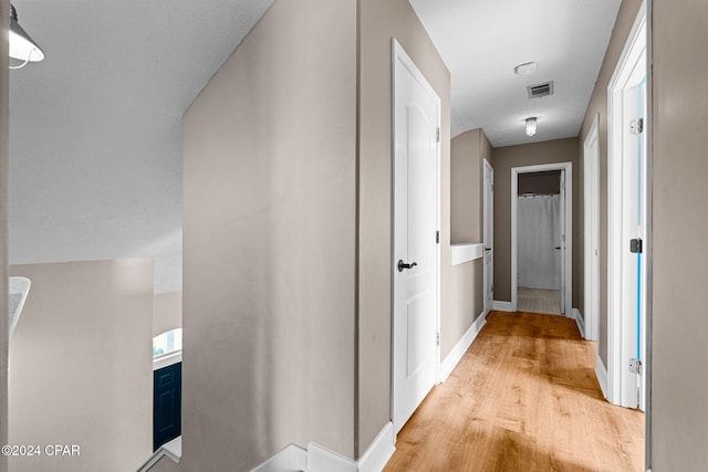 corridor with light hardwood / wood-style flooring