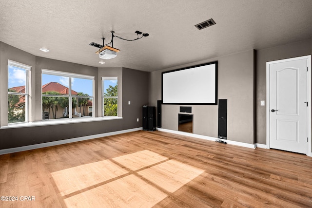 cinema with hardwood / wood-style floors and a textured ceiling