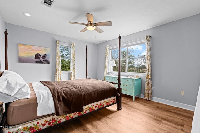 bedroom with multiple windows, ceiling fan, and light hardwood / wood-style flooring