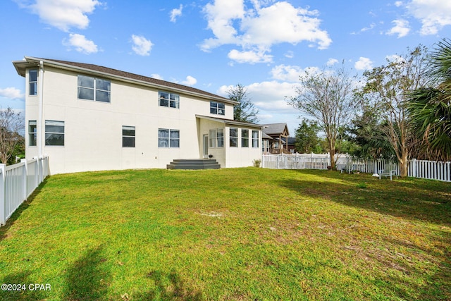 rear view of house featuring a yard