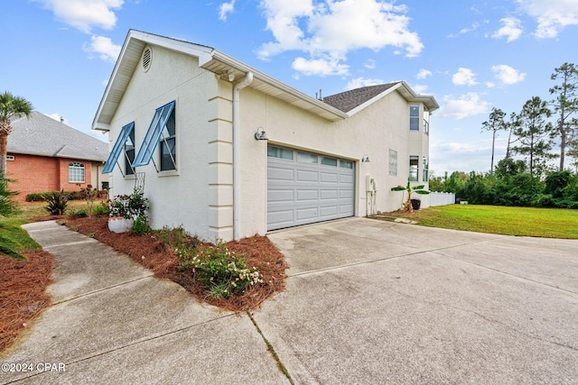 view of side of home with a lawn and a garage