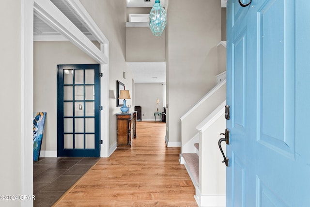 foyer entrance with hardwood / wood-style flooring and a towering ceiling