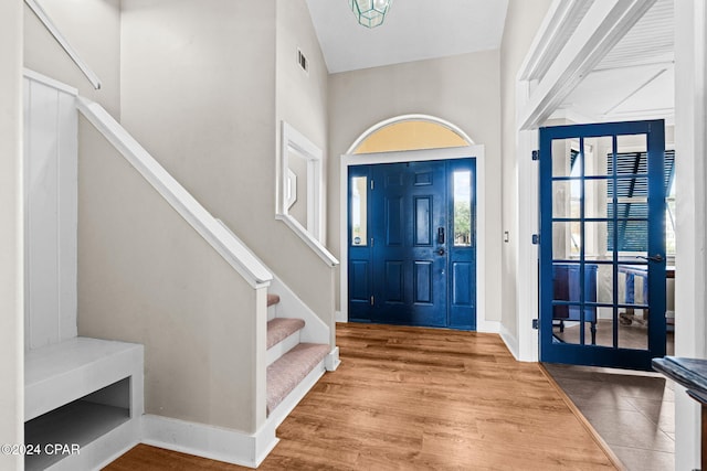 entryway with hardwood / wood-style floors and a high ceiling