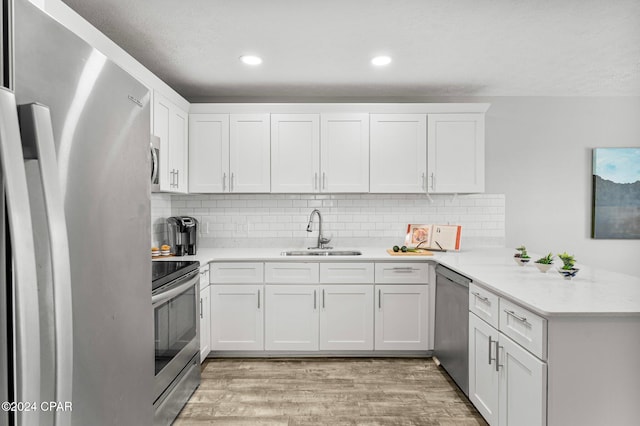 kitchen with white cabinets, light wood-type flooring, sink, and stainless steel appliances