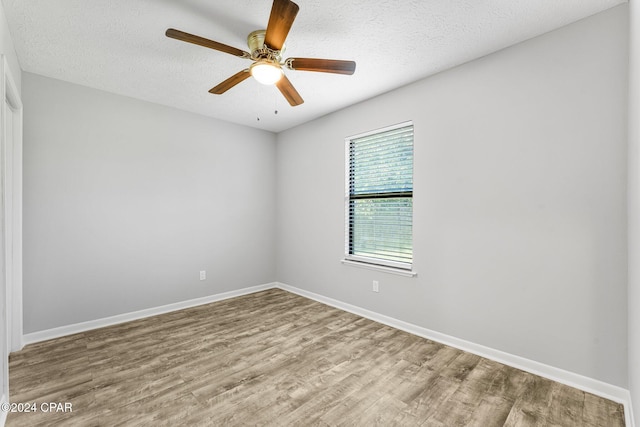 empty room with hardwood / wood-style floors, ceiling fan, and a textured ceiling