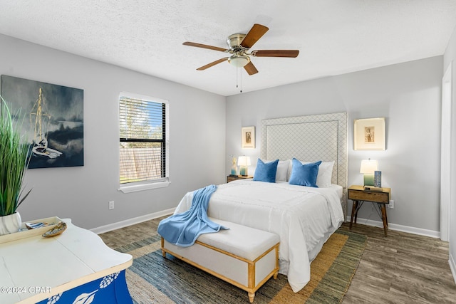 bedroom with ceiling fan, dark hardwood / wood-style floors, and a textured ceiling