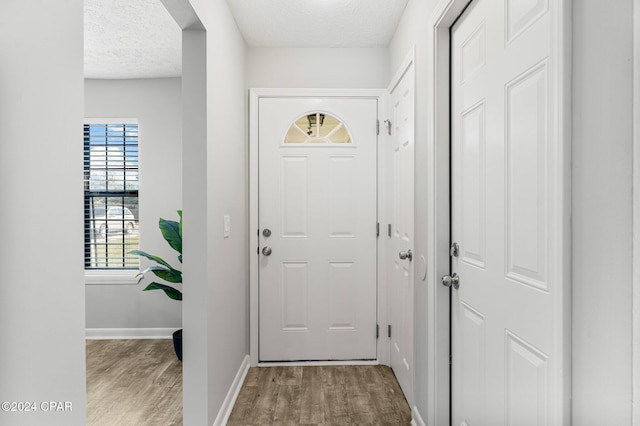 doorway with hardwood / wood-style floors and a textured ceiling