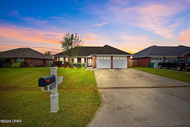 ranch-style home featuring a lawn and a garage