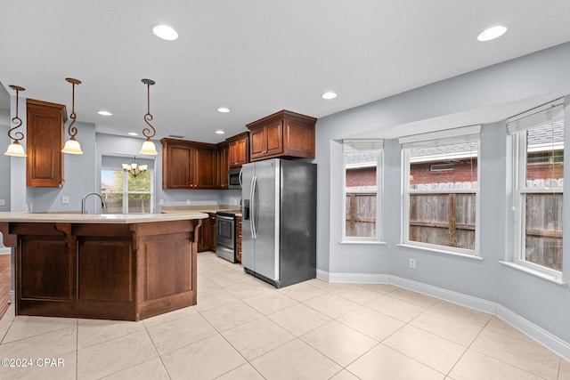 kitchen featuring decorative light fixtures, stainless steel appliances, a wealth of natural light, and sink