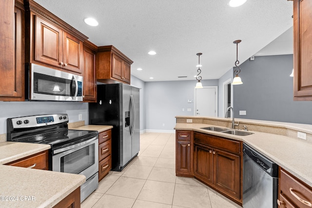 kitchen with sink, hanging light fixtures, a textured ceiling, light tile patterned flooring, and stainless steel appliances