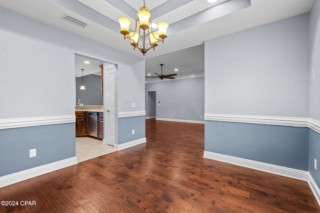 unfurnished room featuring ceiling fan with notable chandelier, sink, and light hardwood / wood-style flooring