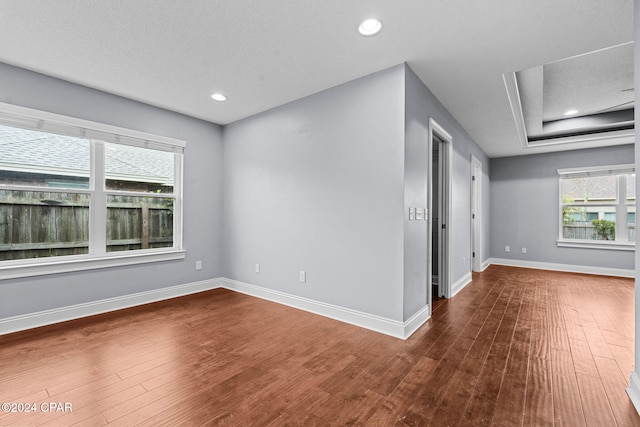 spare room featuring dark wood-type flooring and a textured ceiling