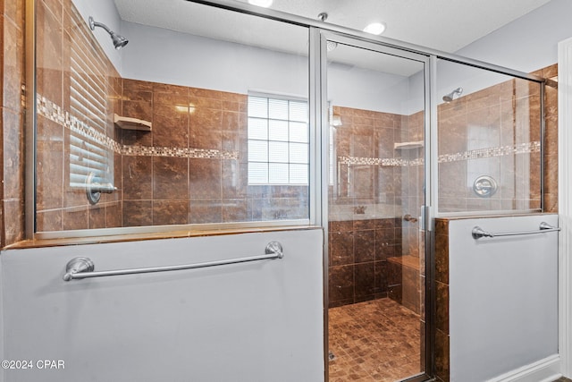 bathroom with a textured ceiling and an enclosed shower