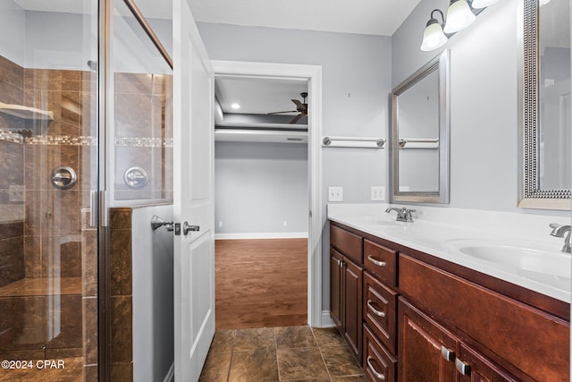 bathroom with ceiling fan, hardwood / wood-style floors, vanity, and a shower with door