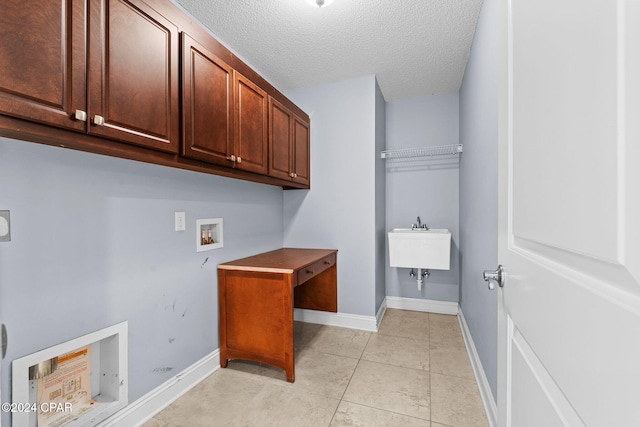 laundry room with electric dryer hookup, cabinets, washer hookup, light tile patterned floors, and a textured ceiling