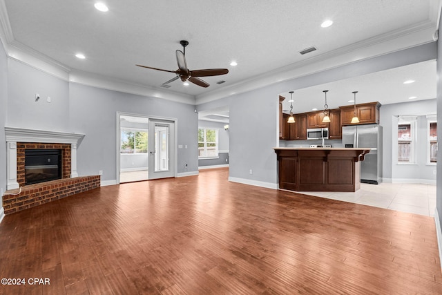 unfurnished living room with a fireplace, light hardwood / wood-style flooring, and ornamental molding