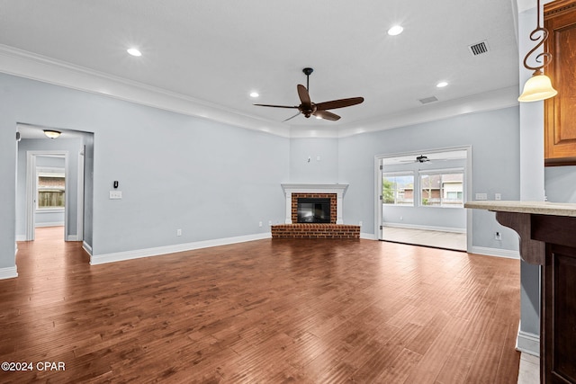 unfurnished living room featuring hardwood / wood-style floors, ornamental molding, and a fireplace