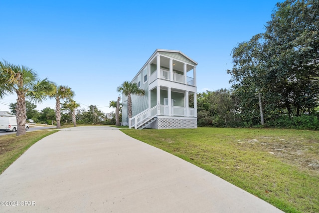 view of front facade with covered porch, a front lawn, and a balcony