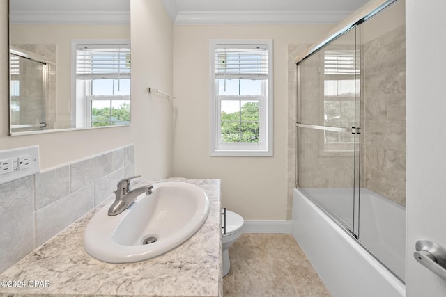 16246 E Lullwater, Panama City Beach, FL 32413 - bathroom featuring ornamental molding, toilet, baseboards, shower / bath combination with glass door, and vanity