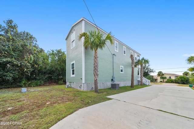 16246 E Lullwater, Panama City Beach, FL 32413 - view of side of property with concrete driveway, a yard, and cooling unit