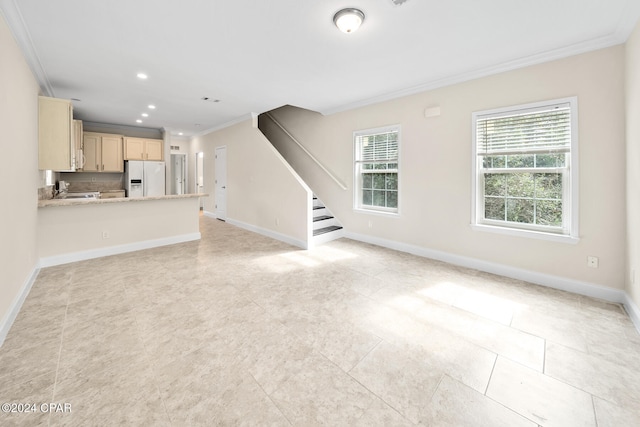 unfurnished living room featuring sink, crown molding, and light tile patterned floors